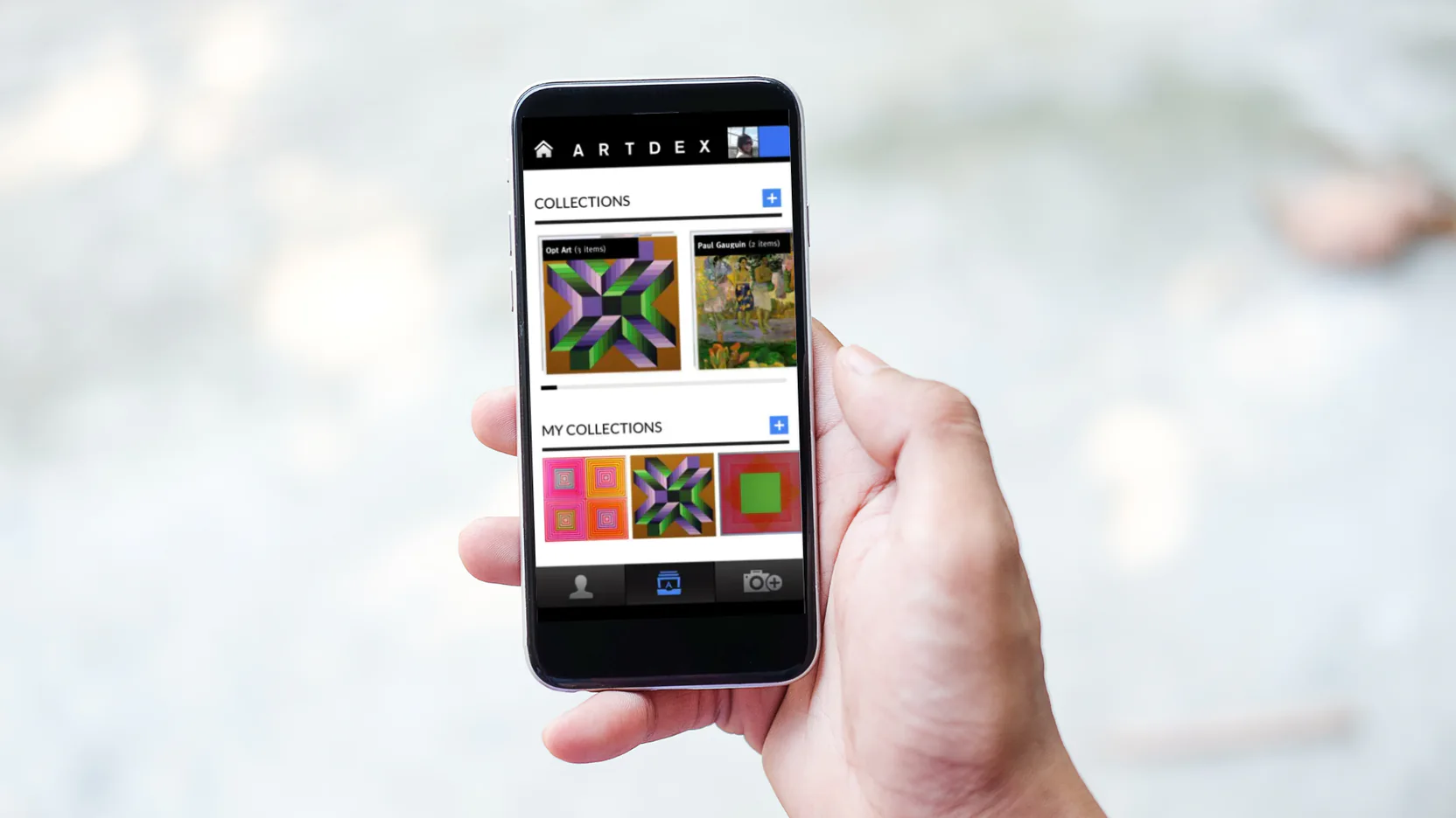 Mão segura um celular com um aplicativo de catalogação de arte aberto, mostrando coleções em miniaturas