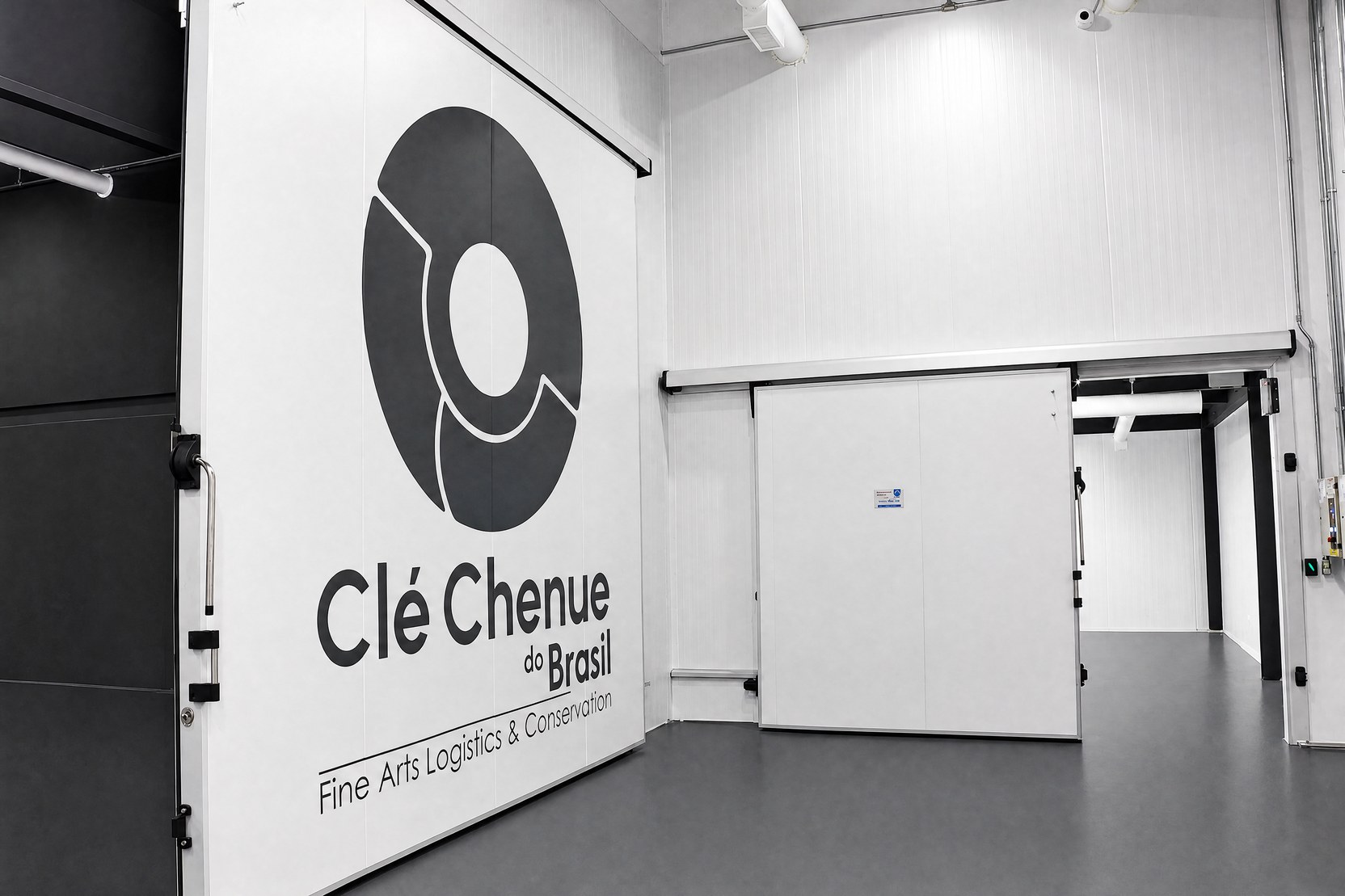 Interior da reserva técnica com parede de isolamento térmico e porta frigorífica com logo da Clé Chenue do Brasil